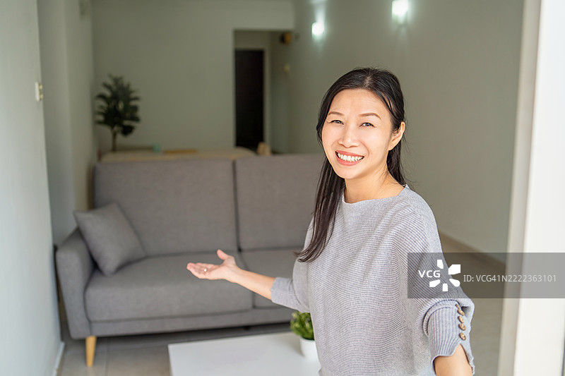 一位亚洲女性庆祝新的开始，她搬进新家并邀请朋友们一起分享这一时刻。图片素材