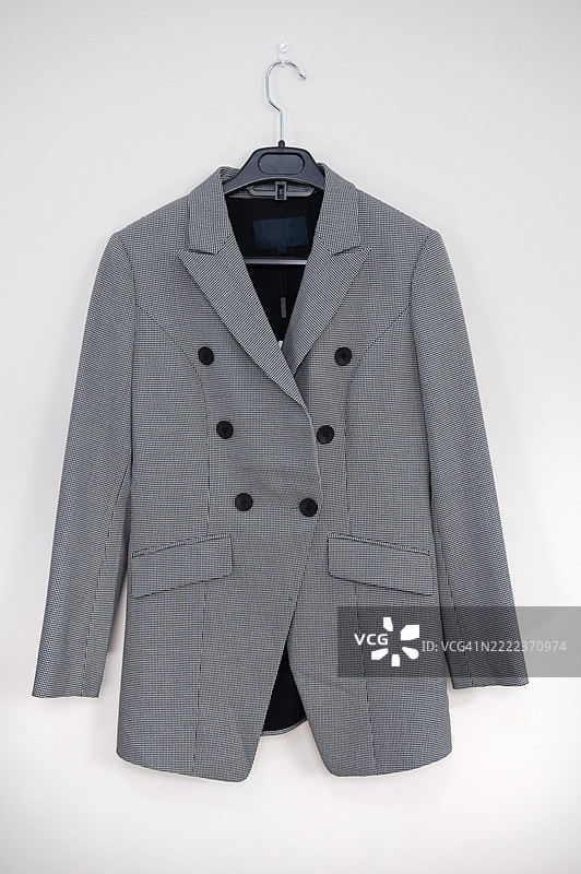 浅灰色西装外套挂在衣架上图片素材