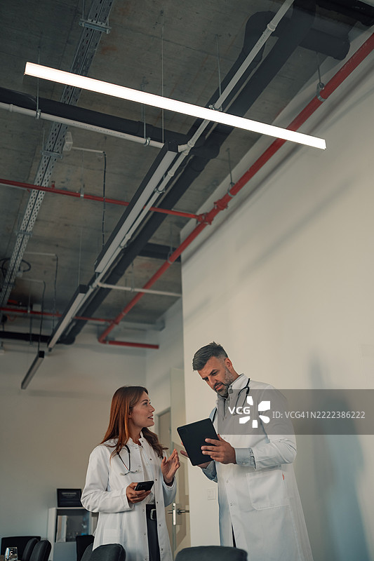 医生在医院讨论数字平板上的病人数据图片素材