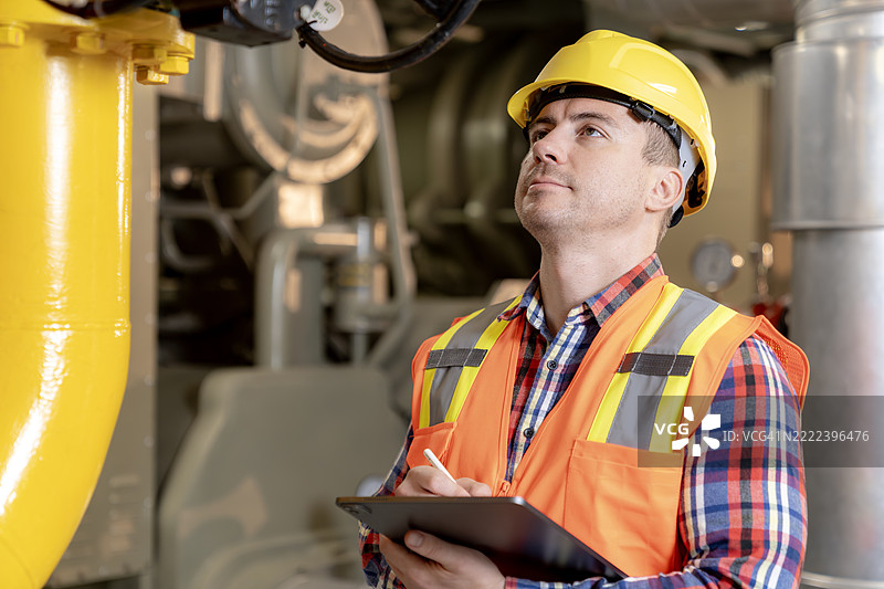 工程师在商业建筑内监控管道网络，以确保系统完整性和公共安全，进行预防性维护。图片素材