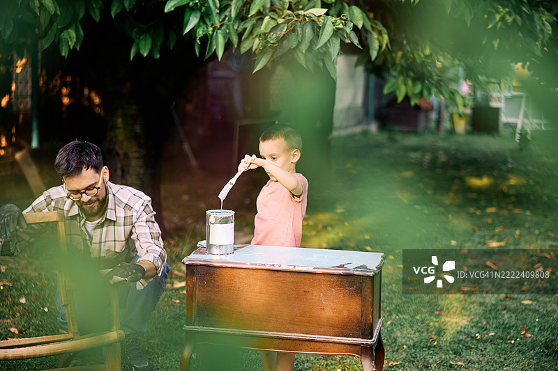 父亲和儿子一起修复乡村风格的家具。图片素材