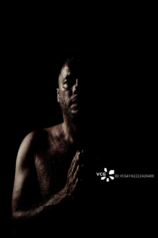 低调的赤裸上身男子祈祷姿势肖像 - 灵性氛围。图片素材