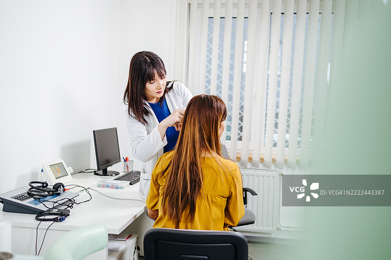 医生在医疗办公室为患者进行听力测试图片素材