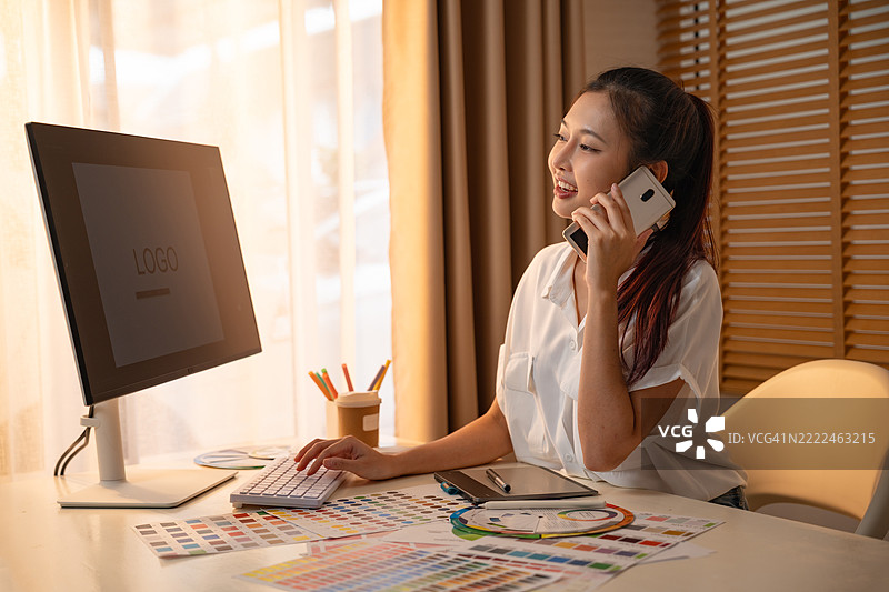 年轻的亚洲女性平面设计师在记录标志设计。色彩样本。艺术家在办公室的图形平板上绘制作品。平面设计师的创意编辑理念概念。图片素材