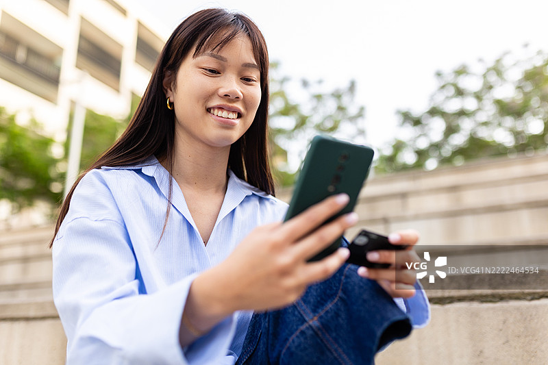 年轻的亚洲女性正在使用智能手机和信用卡进行在线购物图片素材