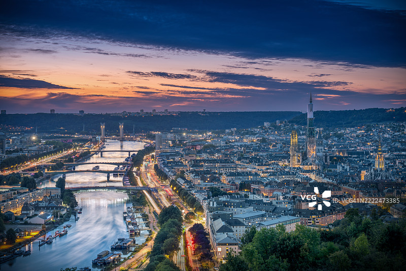 从圣凯瑟琳山俯瞰鲁昂的日落，城市灯光与交通在下方闪烁图片素材