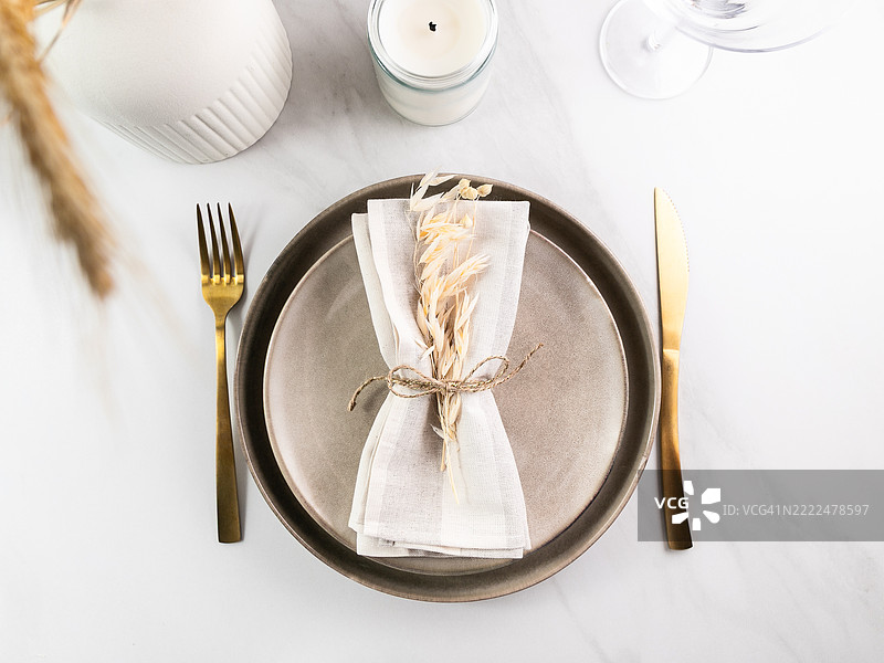 优雅的简约餐桌布置，搭配中性色调的小麦装饰，西班牙图片素材