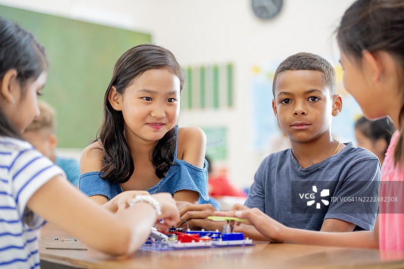 一群多元化的孩子们在合作进行动手科学项目图片素材