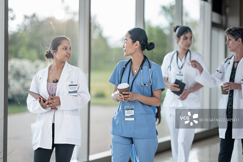 医疗专业人员在现代医疗设施中走动并交谈图片素材