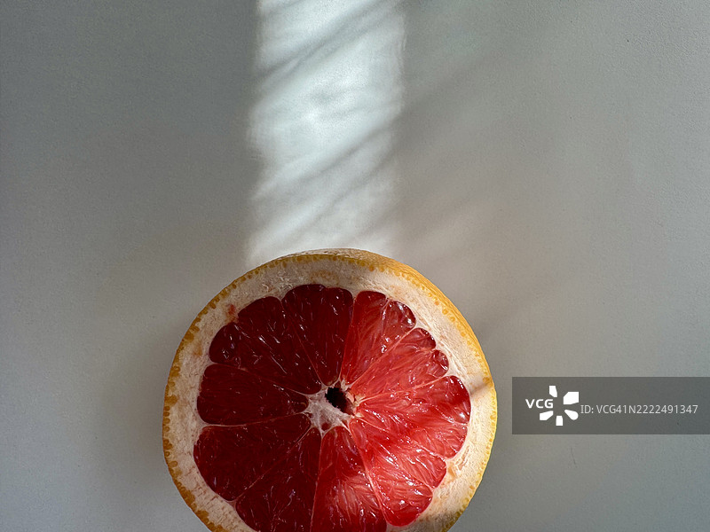 鲜艳的红色葡萄柚切成两半，背景为白色图片素材
