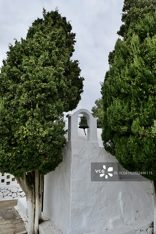 被柏树环绕的白色钟楼，位于希腊米洛斯岛，南爱琴海图片素材