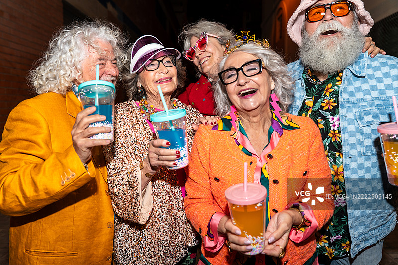 一群穿着华丽服装的快乐老年朋友在西班牙巴塞罗那的夜晚聚会图片素材