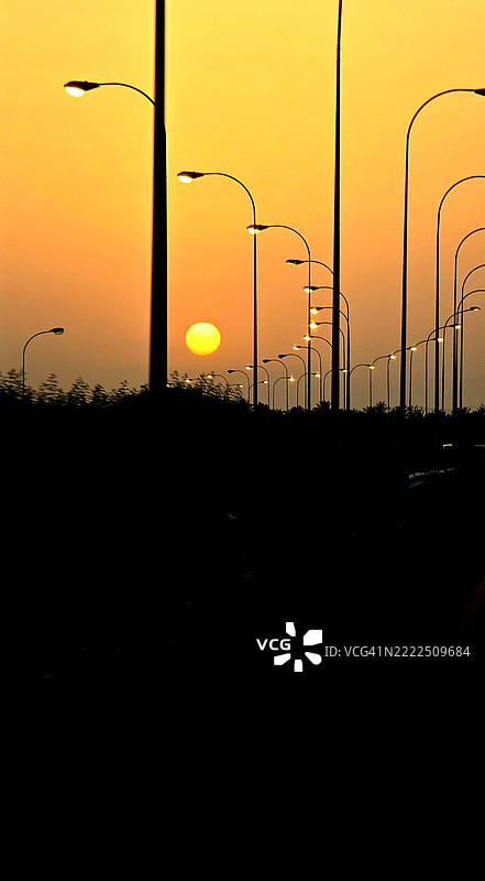 日落时分，苏哈尔，阿尔巴提纳北部，阿曼的街灯剪影与天空相映。图片素材