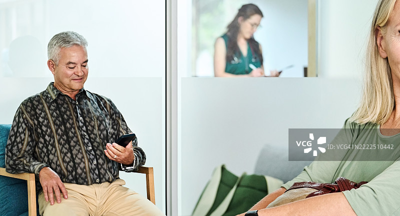 老年男子在诊所候诊室使用手机图片素材