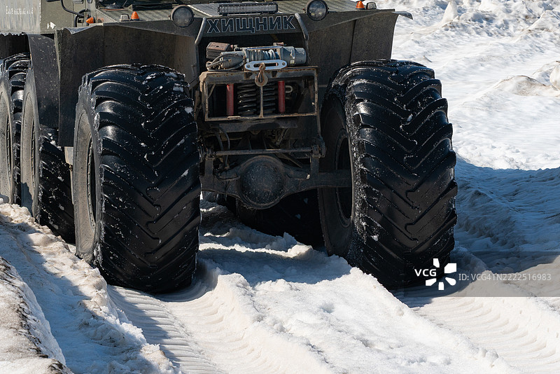修剪视角的雪地越野车捕食者在超低气压轮胎上行驶于被雪覆盖的山路上图片素材