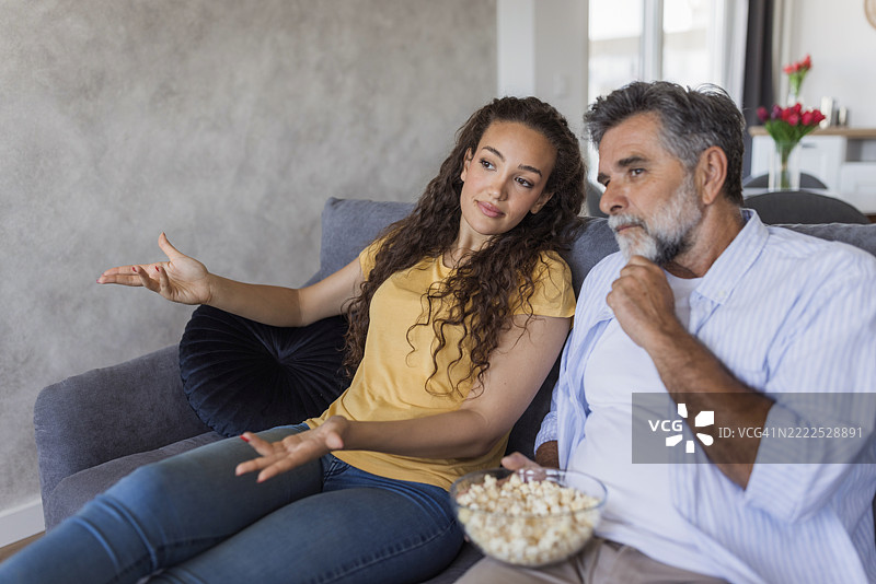 父亲和女儿在家看电影，意见不合图片素材