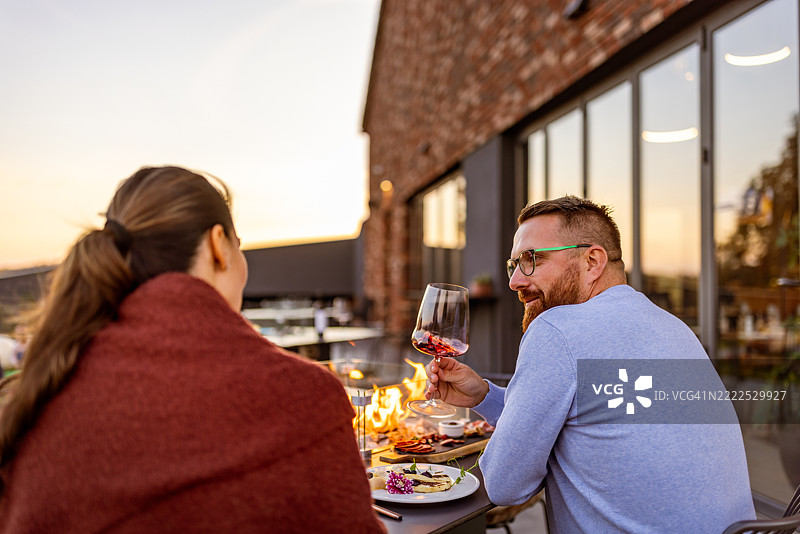 情侣在日落时分享受户外晚餐图片素材