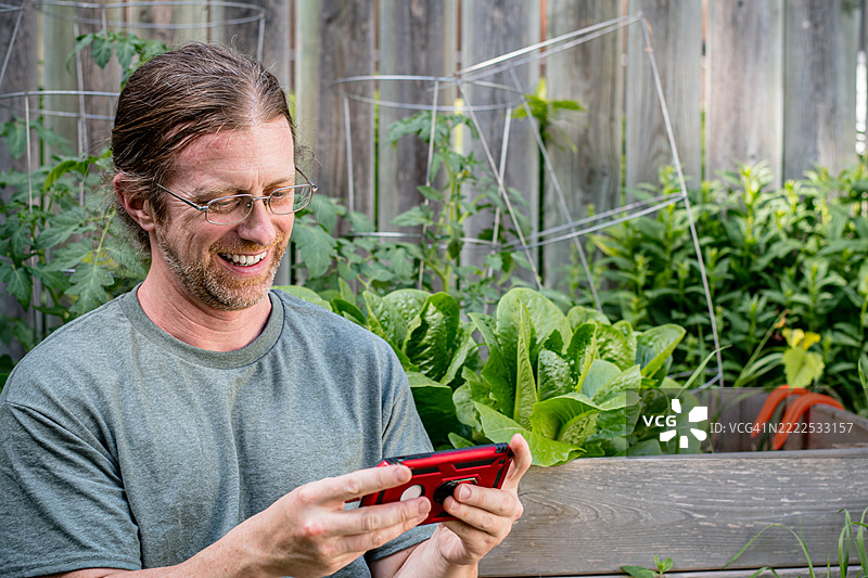 白种男人在户外玩手机游戏图片素材