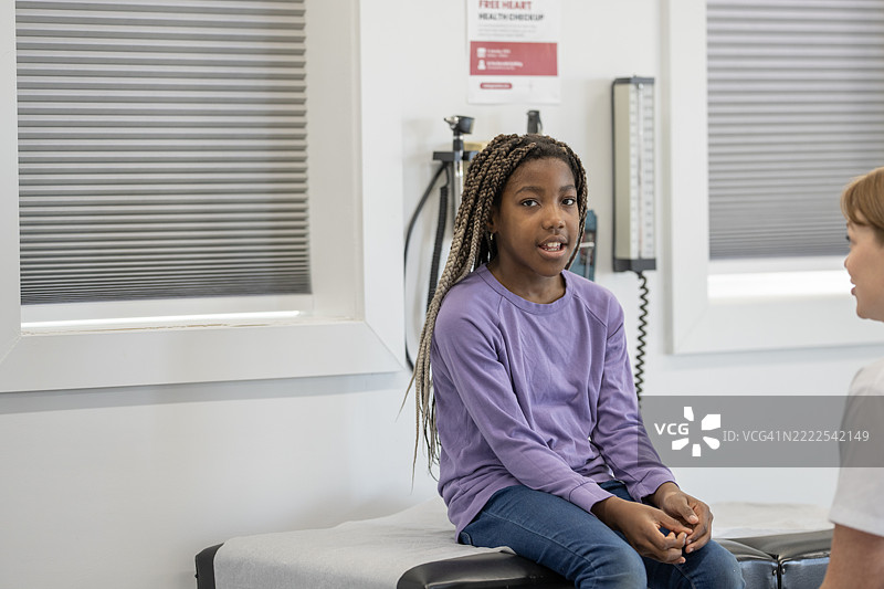小女孩在儿科诊所坐着接受医疗咨询图片素材