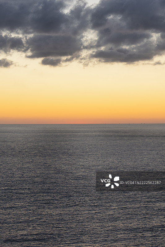 日落时分水面上方的黄色天空图片素材