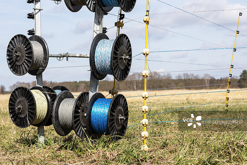 农业田地周围的电围栏电缆卷筒图片素材