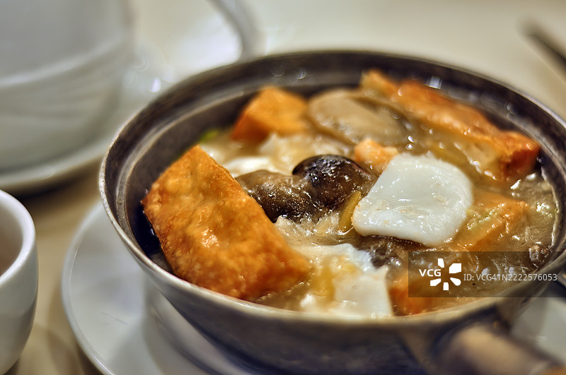 特写镜头展示了一道海鲜豆腐砂锅，盛放在金属锅中。图片素材