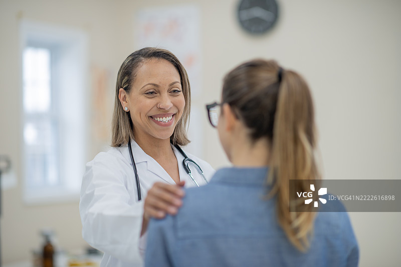 女医生在医疗办公室微笑着与患者交谈图片素材