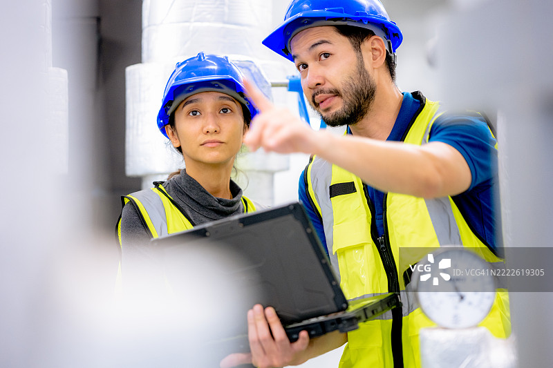两名技术人员进行常规冷却器服务和维护，以确保您的冷却器在最佳效率下运行。图片素材