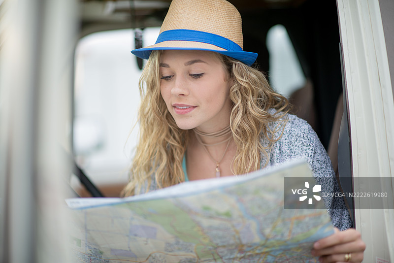 年轻女性在旅行中兴奋地研究地图图片素材