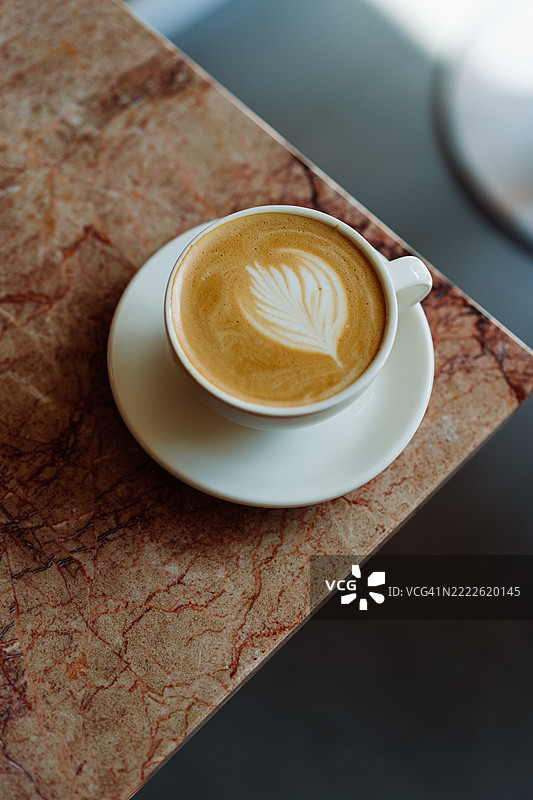 咖啡馆大理石桌上的拿铁艺术卡布奇诺特写图片素材