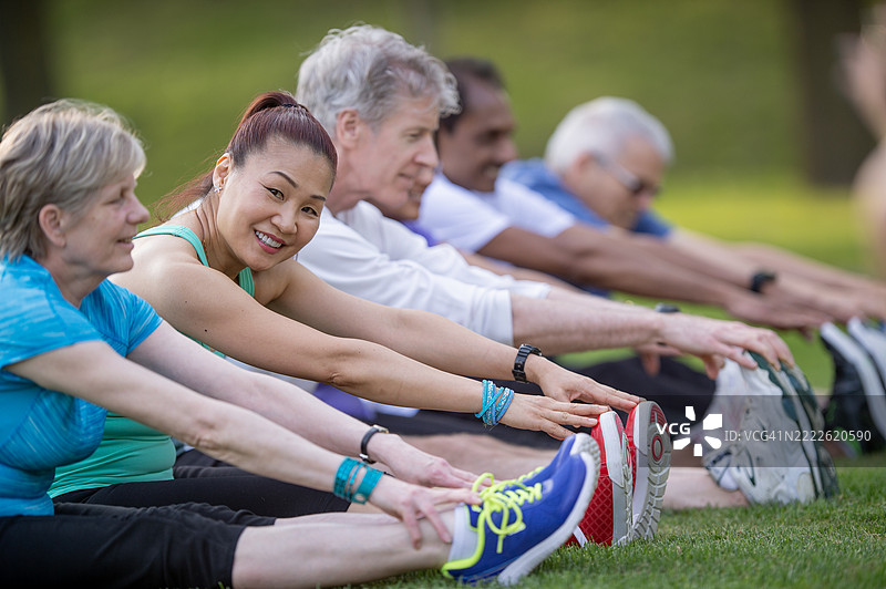 一群活跃的老年人在户外公园一起拉伸图片素材