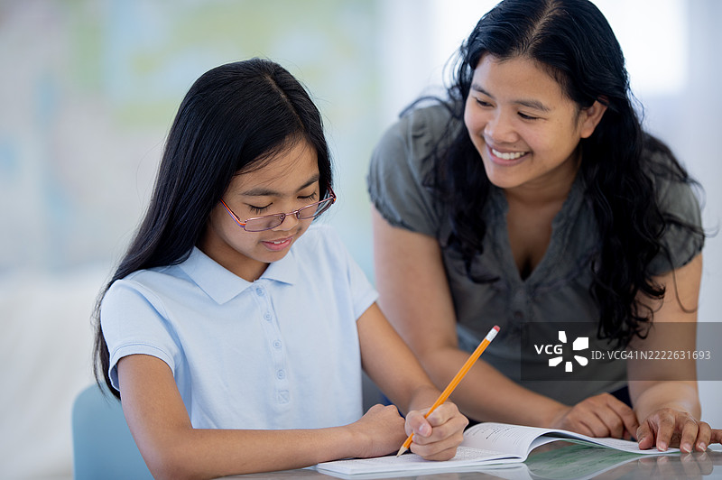 老师在明亮的教室环境中支持学生完成作业图片素材