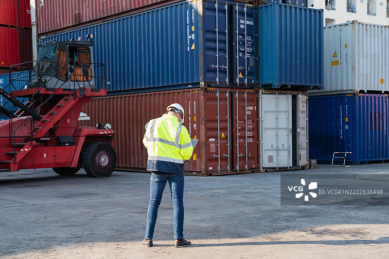 工头和出口团队在港口检查集装箱，管理航运、进口和出口行业的货物运输和物流。图片素材