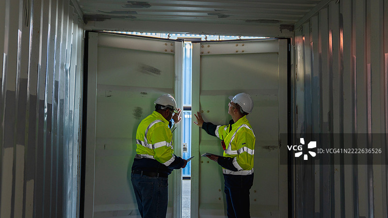 工头和出口团队在港口检查集装箱，管理货物运输，并监督航运和贸易的物流。图片素材