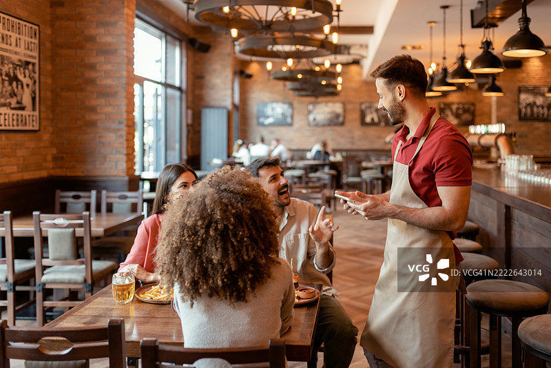 在休闲酒吧用平板电脑记录订单的服务员图片素材
