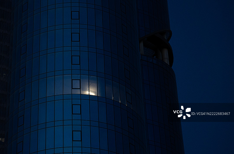 清晨时分，现代建筑中照亮的窗户的低角度视图图片素材