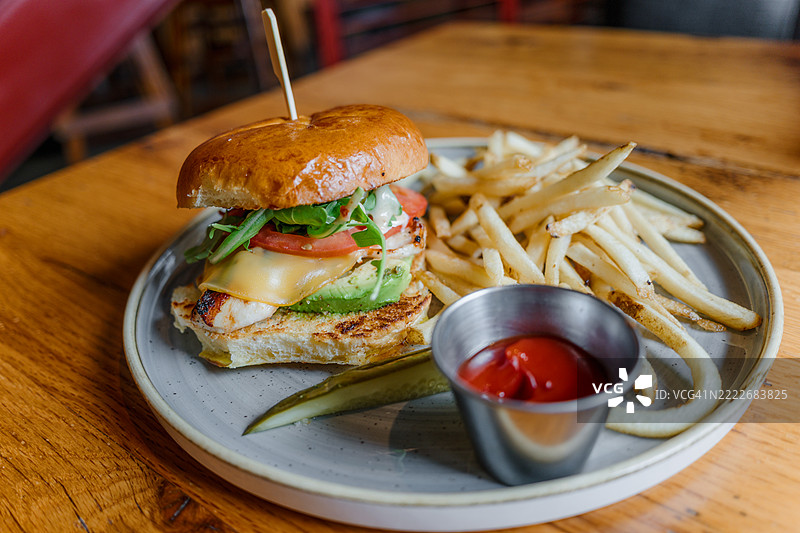 餐厅里的烤鸡肉和鳄梨三明治配薯条图片素材
