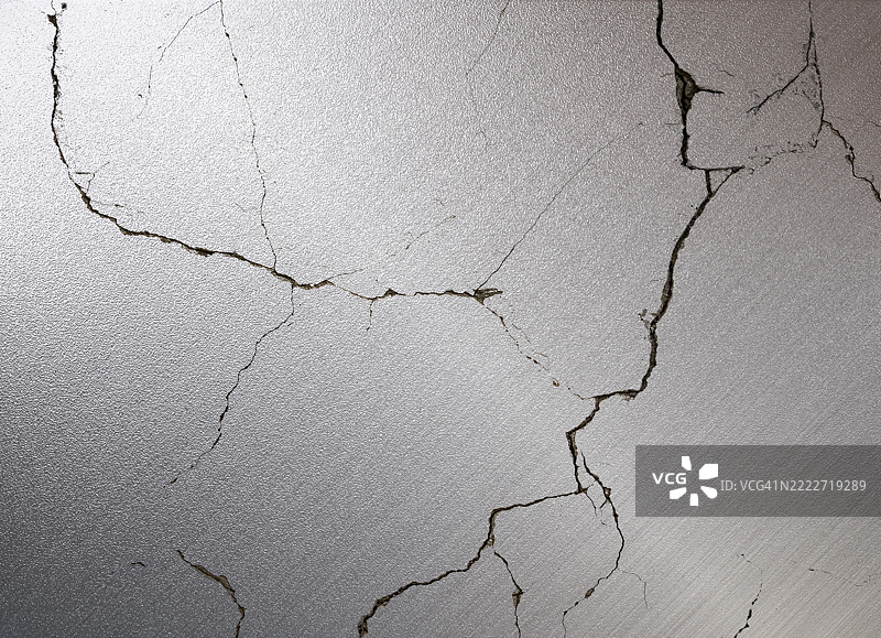 光滑的银色金属质感墙壁，带有深深的裂缝和缝隙。图片素材