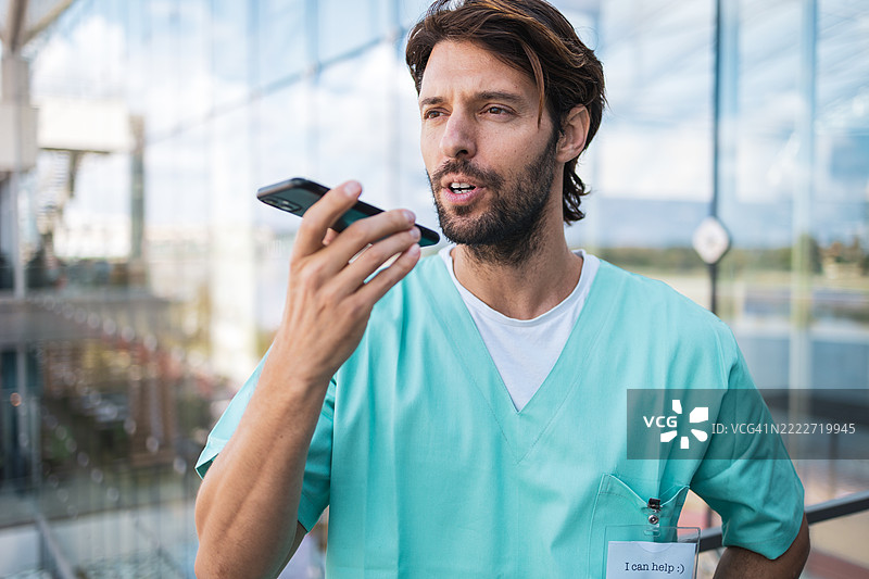 拉丁裔医生使用智能手机发送语音信息图片素材