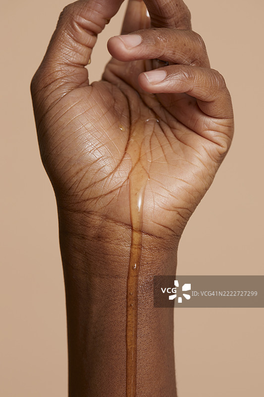 女人手上的蜂蜜，背景为米色图片素材