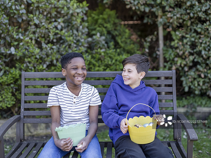男孩们（8-9岁，10-11岁）在复活节寻蛋活动中提着篮子图片素材