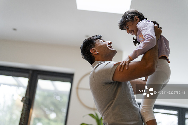 父亲在家中抱起女儿图片素材