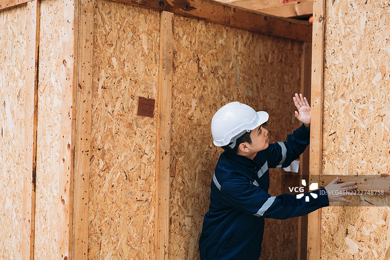 工程师们在宽敞的仓库内仔细检查装在大型木箱中的出口货物，确保质量和准备好进行国际运输。图片素材