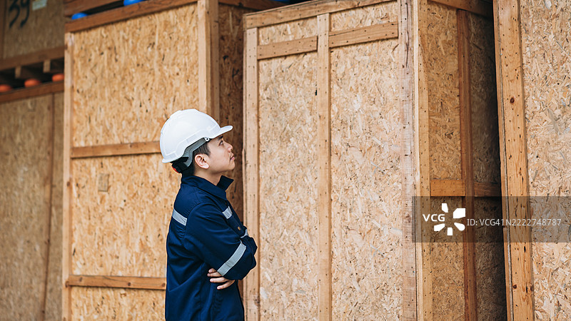 工程师们在宽敞的仓库内仔细检查装在大型木箱中的出口货物，确保质量和准备好进行国际运输。图片素材