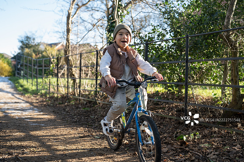 男孩（6-7岁）在乡村骑自行车图片素材