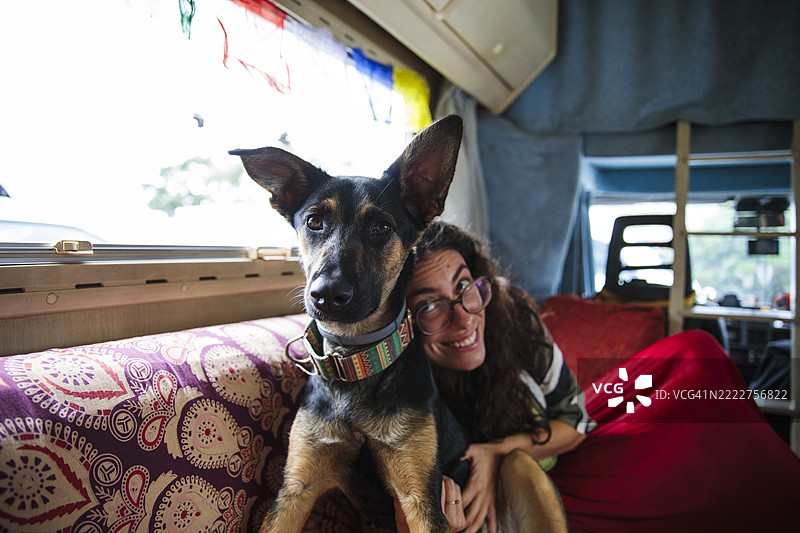 女人在房车旅行时拥抱她的狗图片素材