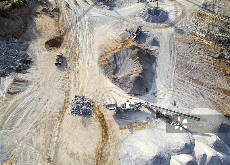 工业采石场作业的鸟瞰图，展示重型机械和挖掘模式图片素材