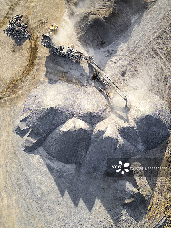 明亮阳光下的采石场鸟瞰图，挖掘机和碎石堆图片素材