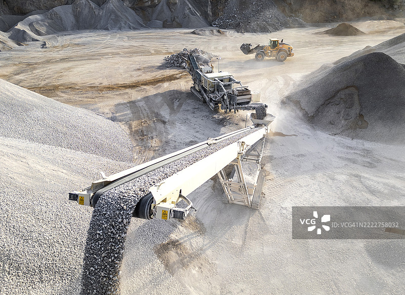 工业碎石加工，配有输送带和机械，位于尘土飞扬的采石场环境中图片素材