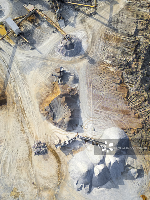 工业采石场的鸟瞰图，展示了机械设备和堆积的矿石材料图片素材